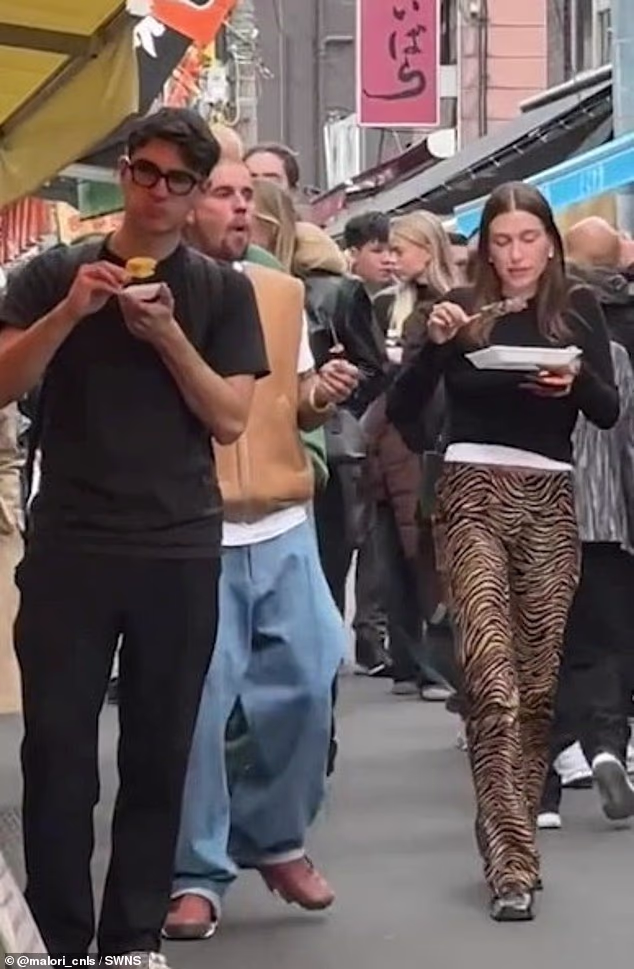 Hailey donned a black jumper over a white shirt and added to her outfit with animal print trousers and black shoes