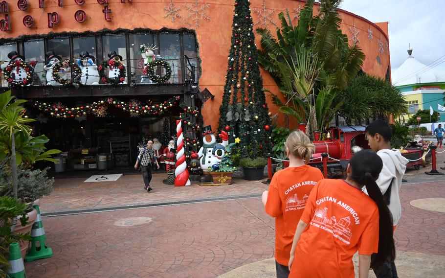 A group of American and Japanese middle school students films the American Depot storefront.
