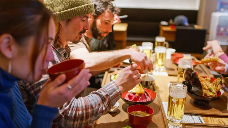 Three friends having a meal in Grand Hirafu after skiing