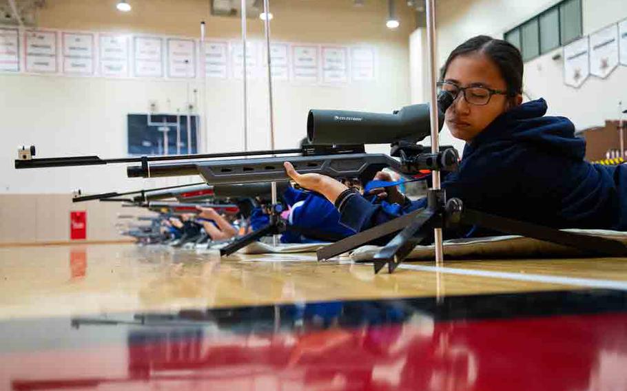 A Yokota High cadet sets her sights before firing from the prone position during the Pacific East Regional Marksmanship Match at Matthew C. Perry High School on Marine Corps Air Station Iwakuni, Japan, Dec. 6, 2025.