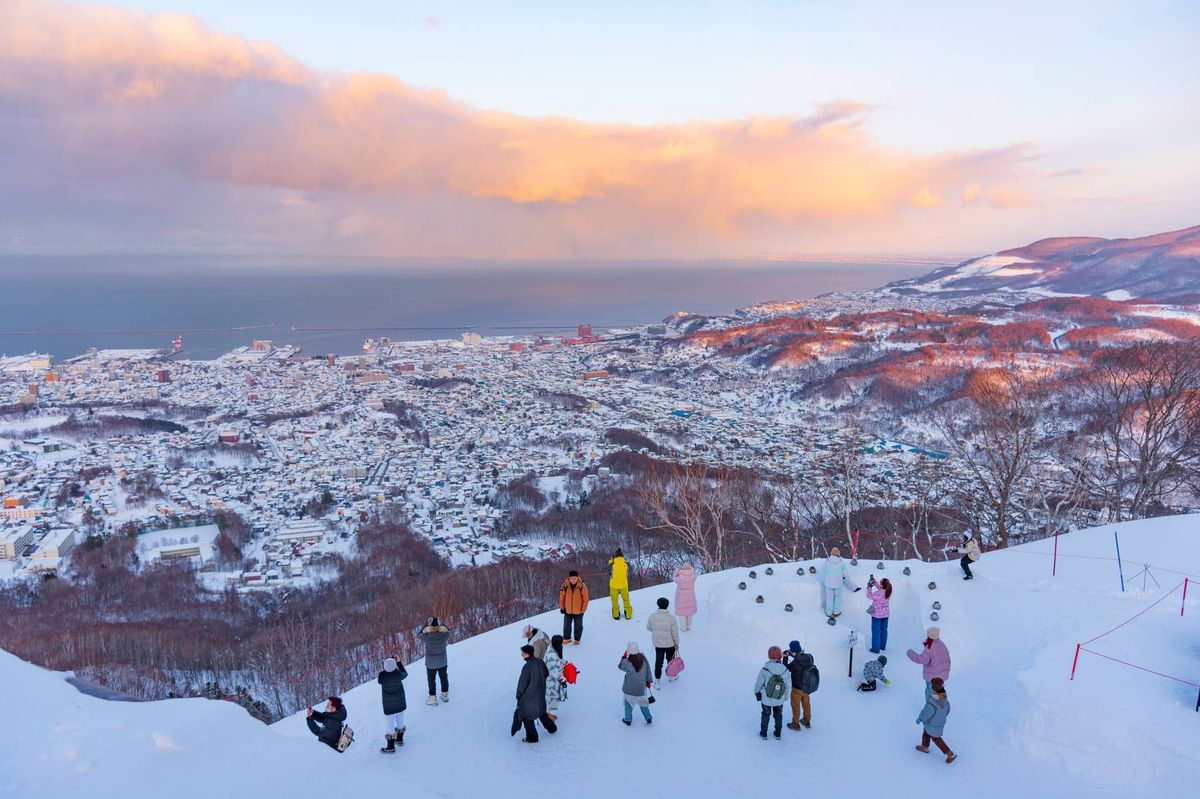 Tourists enjoy sightseeing scenic view of Otaru city from Mt. Tenguyama 