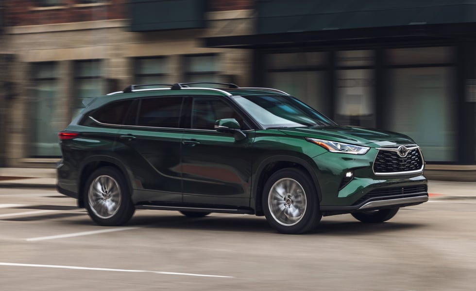 front three quarter view of green suv in motion on urban road with blurred background.