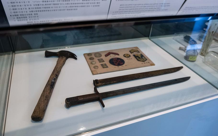 A sword and a hummer in a showcase.