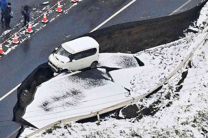 This aerial photo shows a vehicle sitting on a damaged road in Tohoku town, Aomori prefecture, northern Japan Tuesday, Dec. 9, 2025, following a powerful earthquake on late Monday. (Kyodo News via AP)