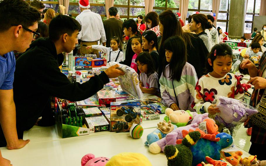 Marines of 3rd Intelligence Battalion and Kubasaki High School JROTC cadets deliver donated toys to children.