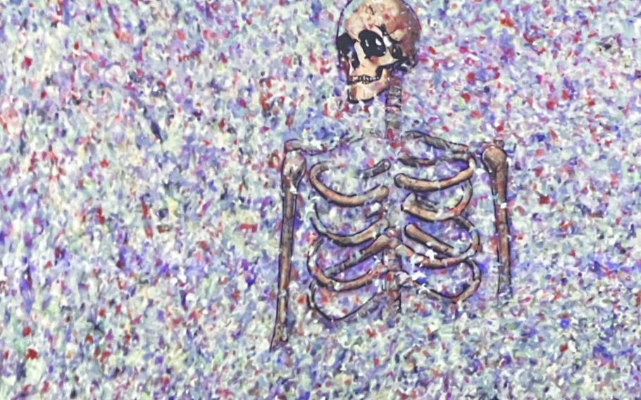 A video screen shows a drawn image of a skeleton surrounded by colorful confetti.
