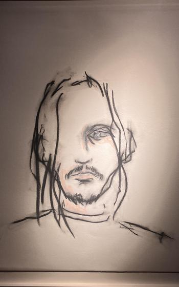 A rough charcoal drawing shows a man’s face, hair and shoulders.