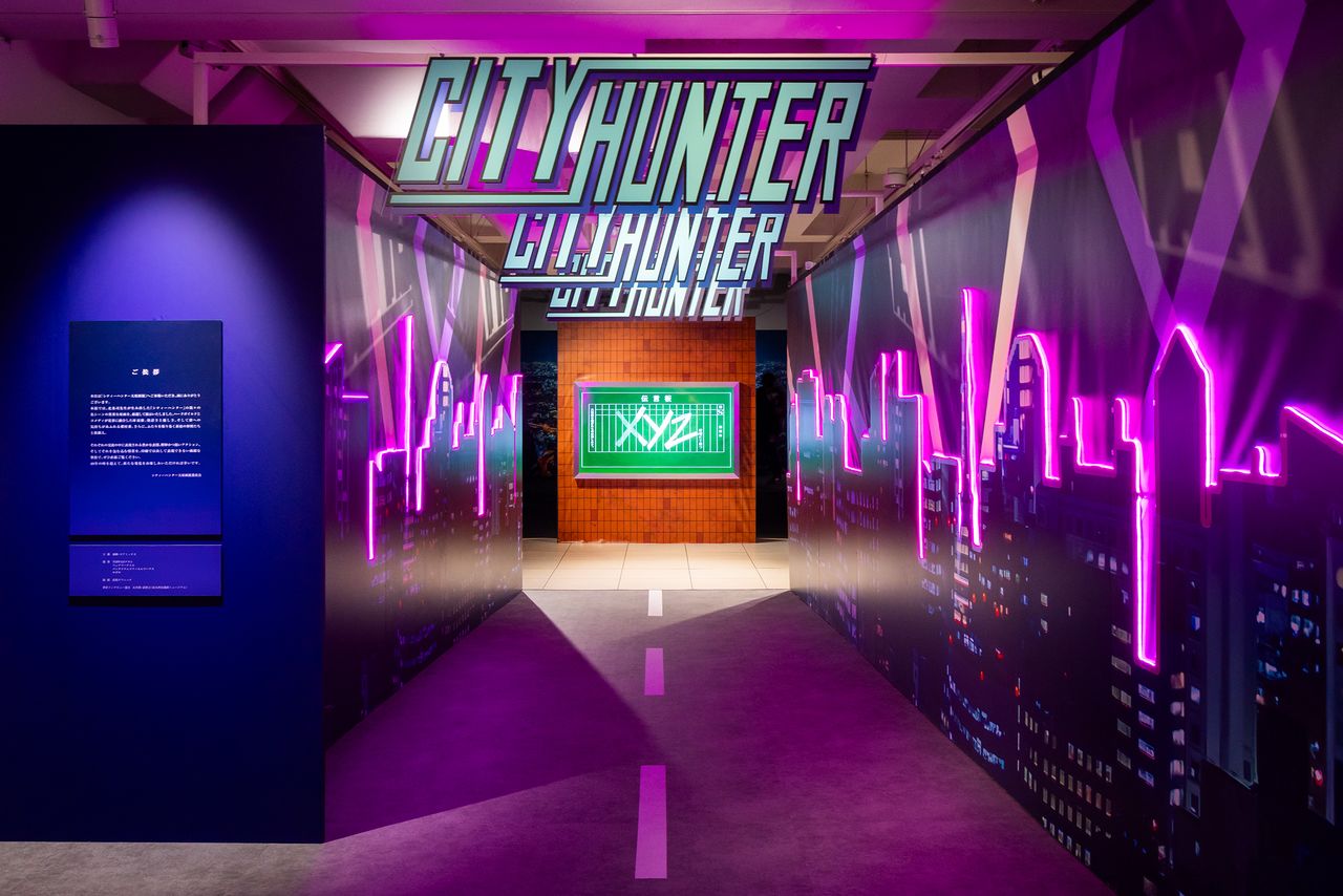 The story begins for exhibition visitors as the neon nightscape of Shinjuku gives way to a bulletin board where the letters “XYZ” glow into view. (© Nippon.com)