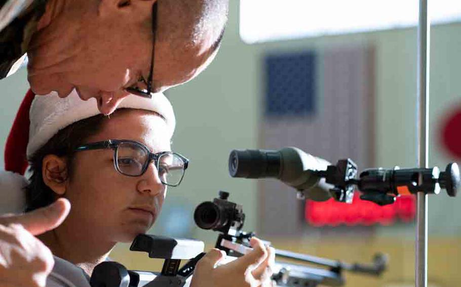 A JROTC cadet from Matthew C. Perry High School listens to advice during the Pacific East Regional Marksmanship Match at Marine Corps Air Station Iwakuni, Japan, Dec. 5, 2025.