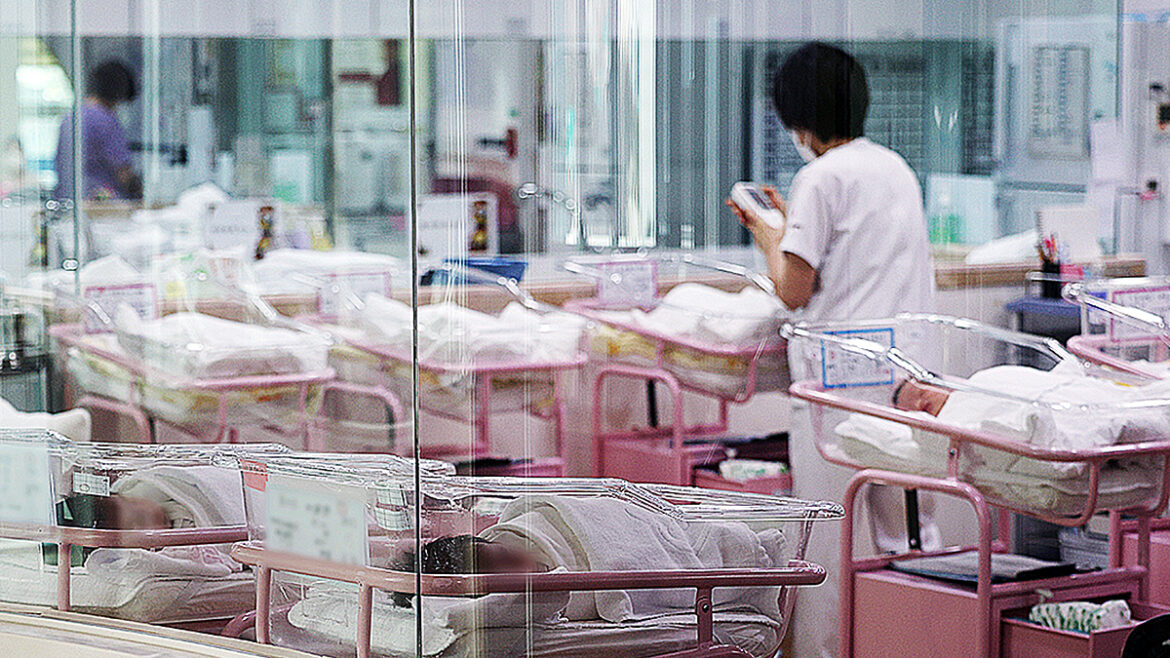 A staff member cares for newborns in a nursery at a postpartum care center in Seoul on Feb. 28, 2024. [YONHAP]