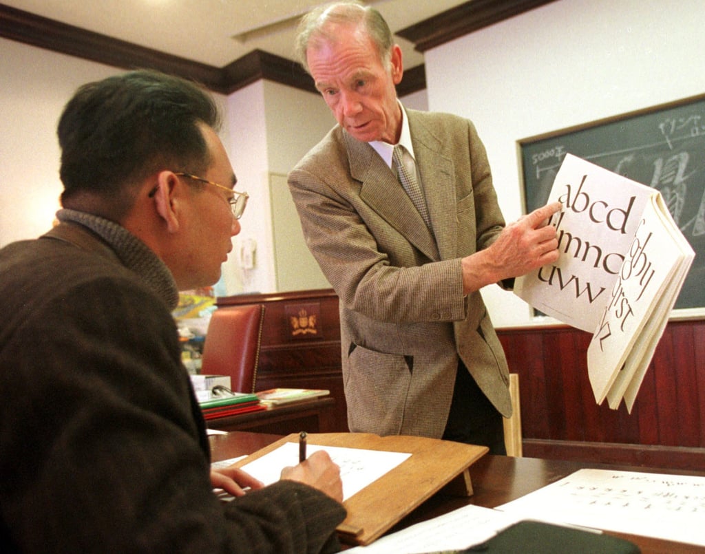 A British teacher shows a Japanese student how to write English calligraphy in 2000. Photo: AP