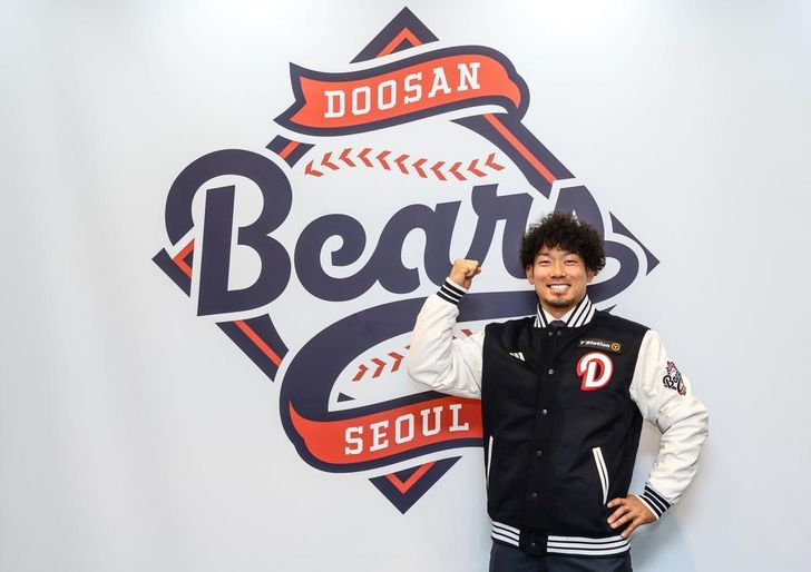 New Doosan Bears pitcher Ichiro Tamura poses in front of the team's logo at Jamsil Baseball Stadium in Seoul, Thursday, after signing a contract with the Korea Baseball Organization club. Courtesy of Doosan Bears