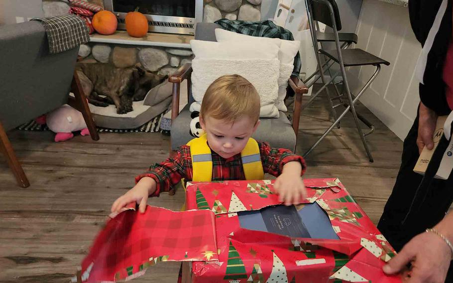 a little child opening a Christmas present