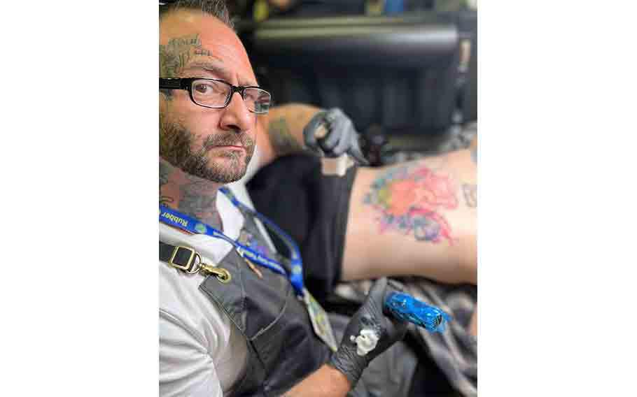 Lord Grim getting a customer’s back inked.