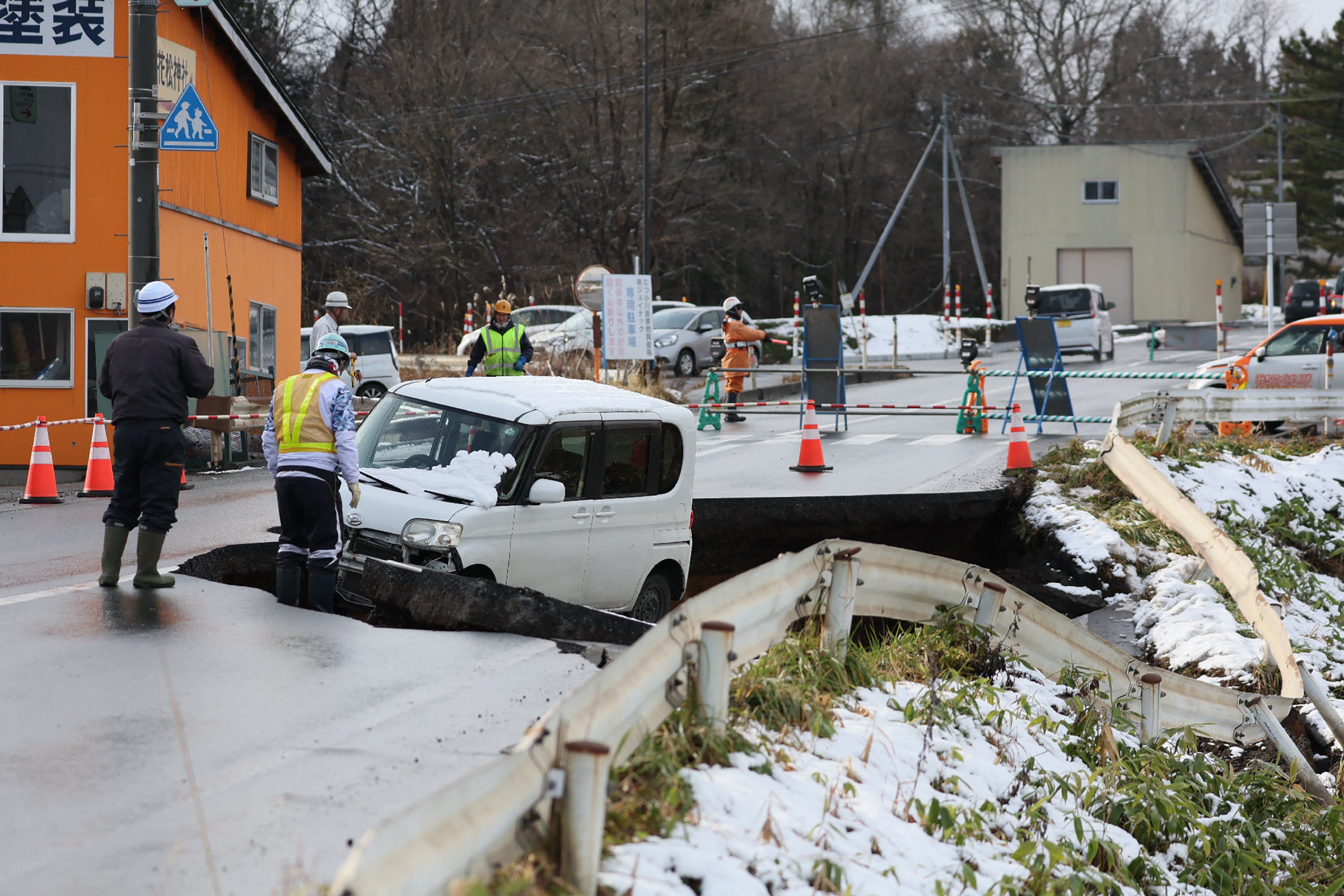 A vehicle is seen on a collapsed road in Tohoku town in Aomori Prefecture on 9 December 2025, following a 7.5 magnitude earthquake off northern Japan