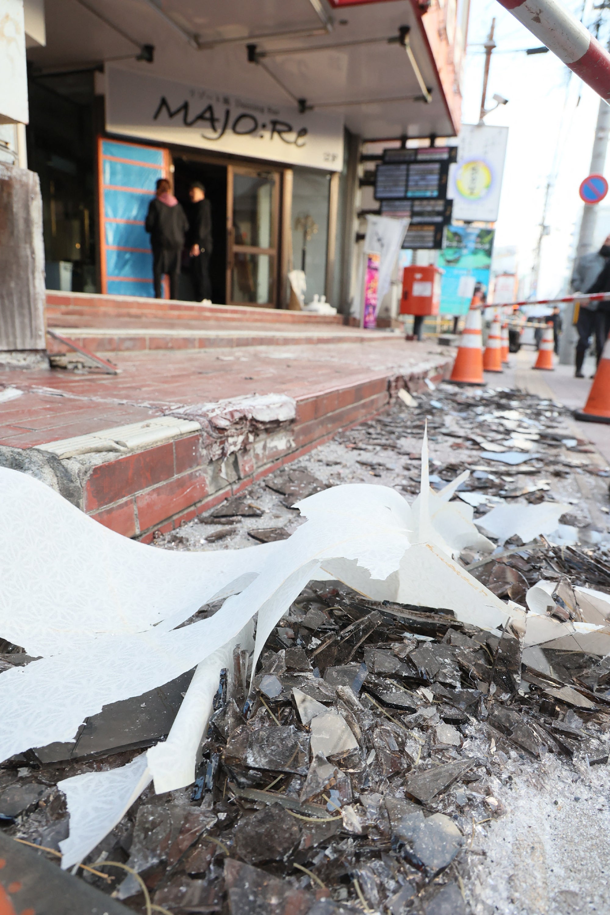 Broken window glass scattered on the street in front of a building is seen in Hachinohe City in Aomori Prefecture on 9 December 2025, following a 7.5 magnitude earthquake off northern Japan