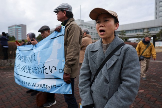 Ayako Oga, 52, who settled in Niigata after fleeing the area around the Fukushima Daiichi nuclear plant in 2011, takes part in a rally in front of Niigata prefectural government office building before voting takes place in the prefectural assembly on a partial restart of the Tokyo Electric Power Company's (TEPCO) Kashiwazaki Kariwa Nuclear Power Plant, one of the world's largest nuclear power plants and which was among the reactors shut after a massive earthquake and tsunami in 2011 crippled TEPCO's Fukushima Daiichi plant, in Niigata, Japan December 22, 2025. REUTERS/Issei Kato