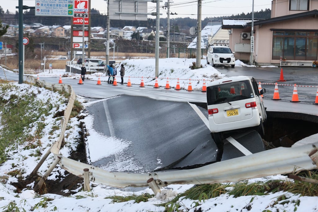 A car is seen stranded on a stretch of collapsed road in Aomori prefecture, northeastern Japan, last Tuesday following a powerful magnitude 7.5 earthquake. Photo: Jiji Press/EPA