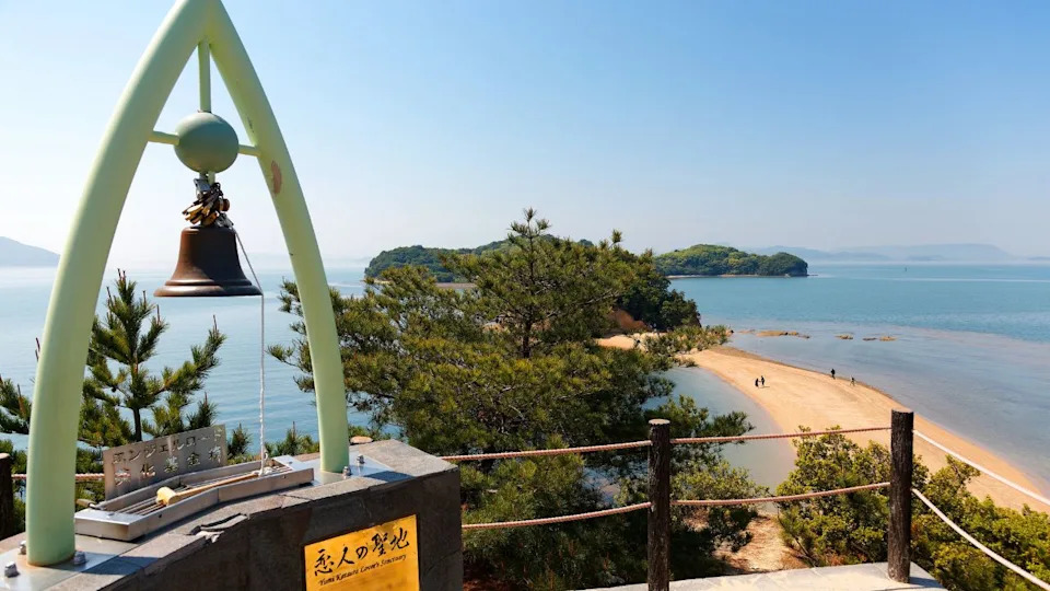 A bronze bell on the viewpoint atop "Hill of Commitment, Lovers' Sanctuary" overlooking the Angel Road, a tidal sandbar and a famous tourist attraction in Tonosho, Shodoshima Island, Kagawa, japan