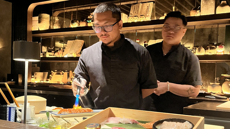 chef blow-torching sushi