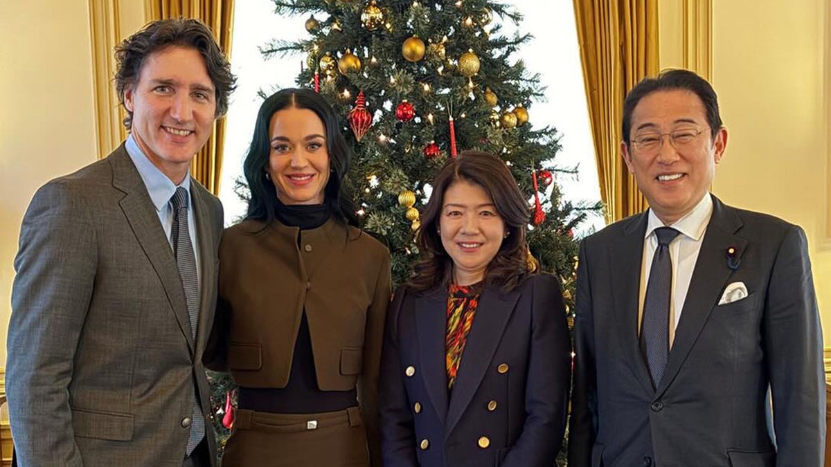 Katy Perry smiles next to Justin Trudeau and Japan's former prime minister Fumio Kishida and his wife Yuko.
