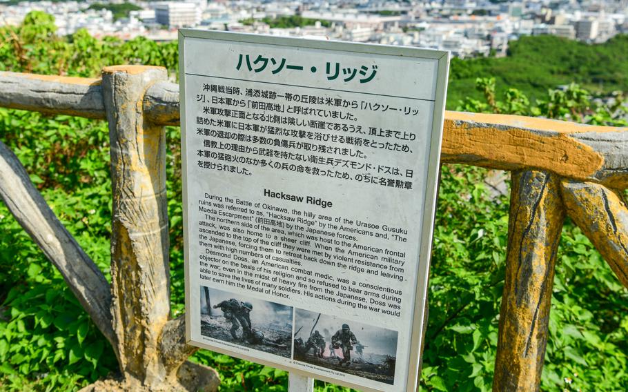 A sign explains the history of an outlook along a fence.