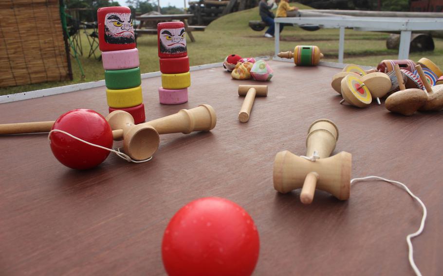 Kendama (Japanese cup-and-ball game) and Daruma Otoshi (a traditional Japanese game where you knock out the bottom blocks with a hammer without letting the top doll fall) on the table