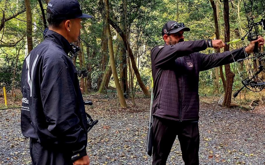 Japanese hip-hop artist AK-69, left, visited the archery trail at Tama Hills Recreation Area in Tokyo on Nov. 16, 2025, where he practiced shooting foam animal targets with manager Patrick Bowman.