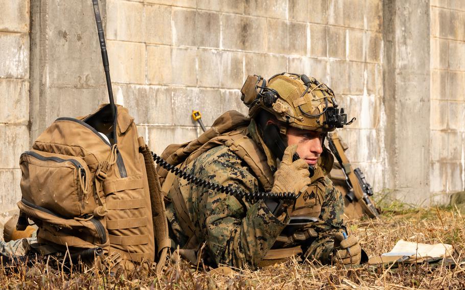A mortarman checks his radio while conducting platoon attacks.
