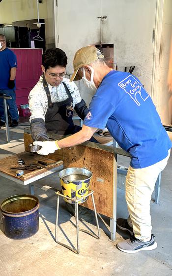 Shoji is bening helped to make a glass.