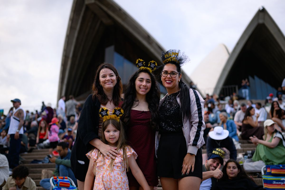 People pose for photo ahead of the New Year's Eve fireworks display at Opera House