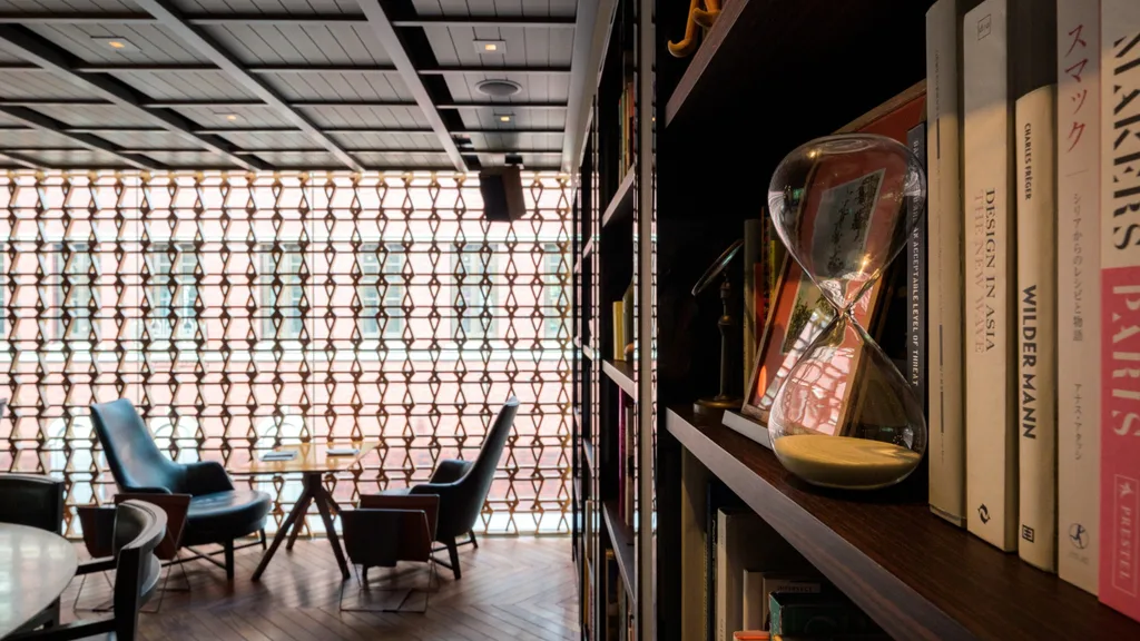 A timber room with abstract breezeblocks and velvet blue chairs