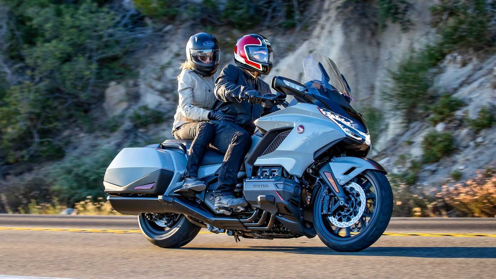 2020 Honda Gold Wing with rider and pillion accelerating side profile view