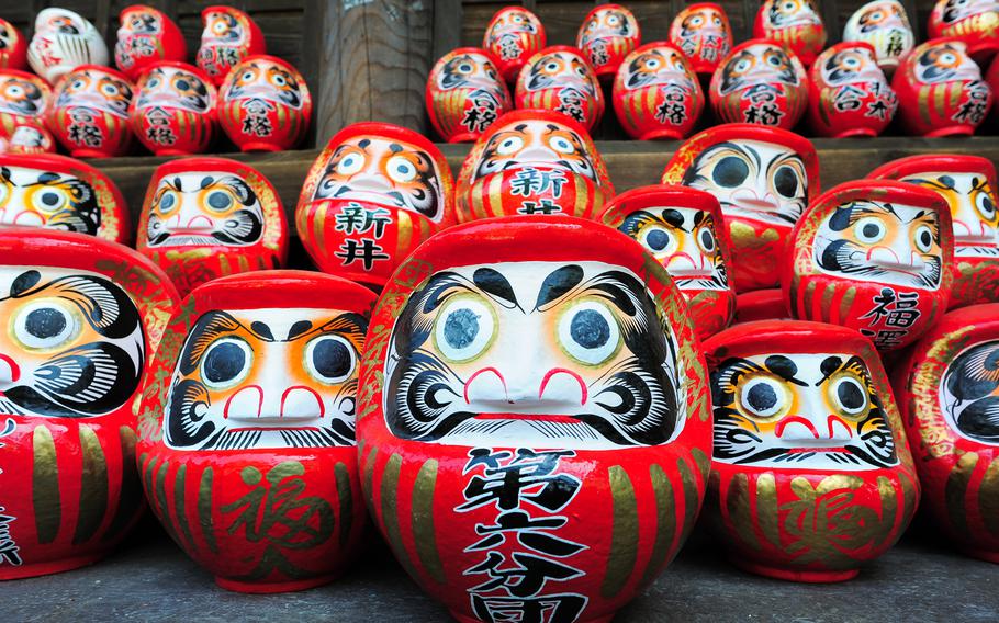 Daruma dolls with different writing on each of them.