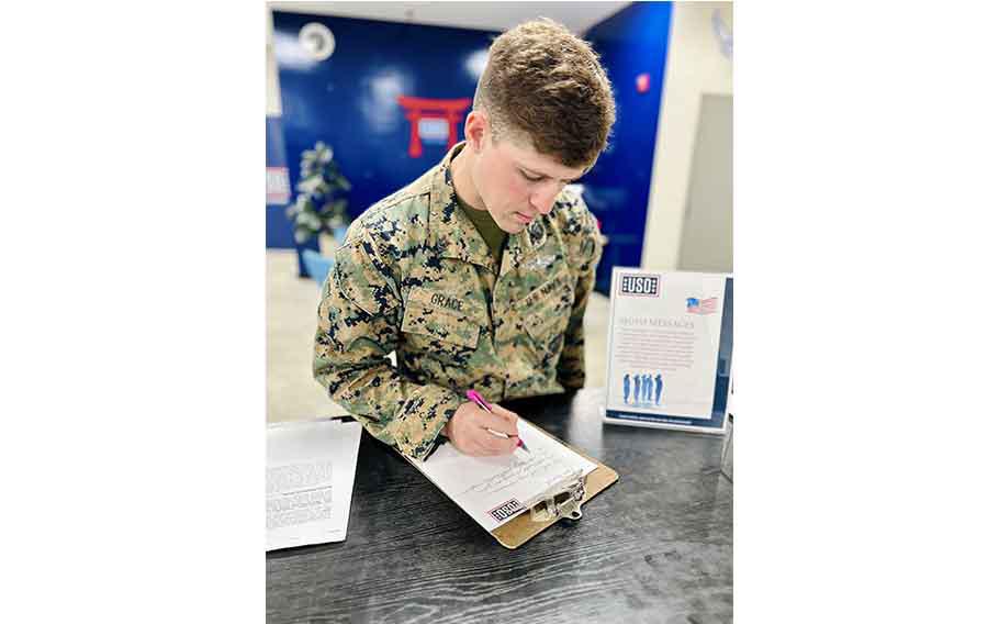 A military personnel filling out a note.