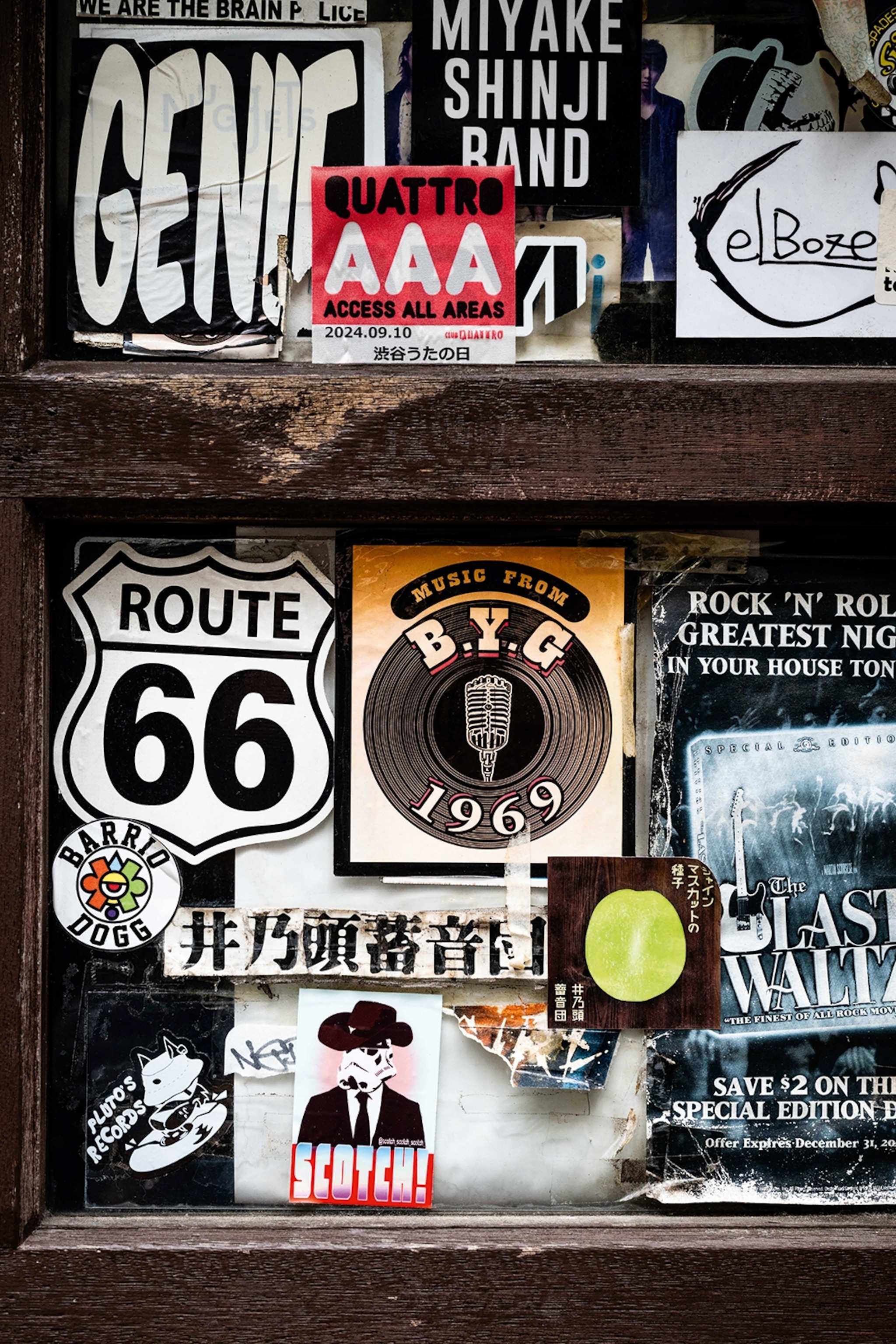 A close-up of a wall with various stickers, including a 'Route 66' and cowboy storm trooper sticker.