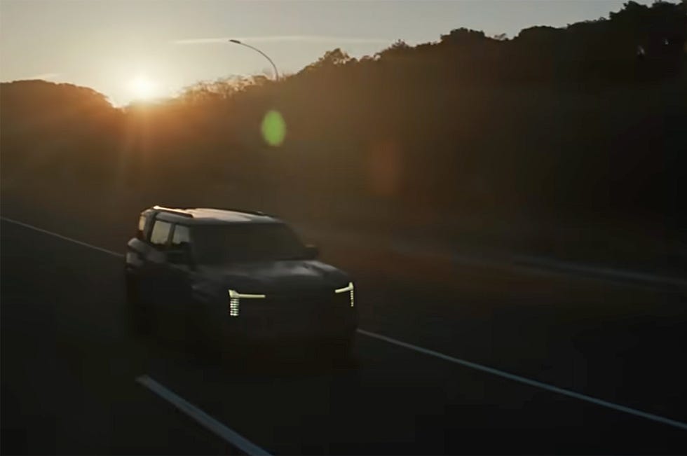 a vehicle driving on a road at sunset
