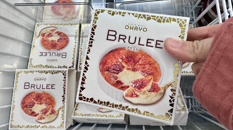 Hand holding Ohayo Brulee above freezer in Japanese 7-eleven