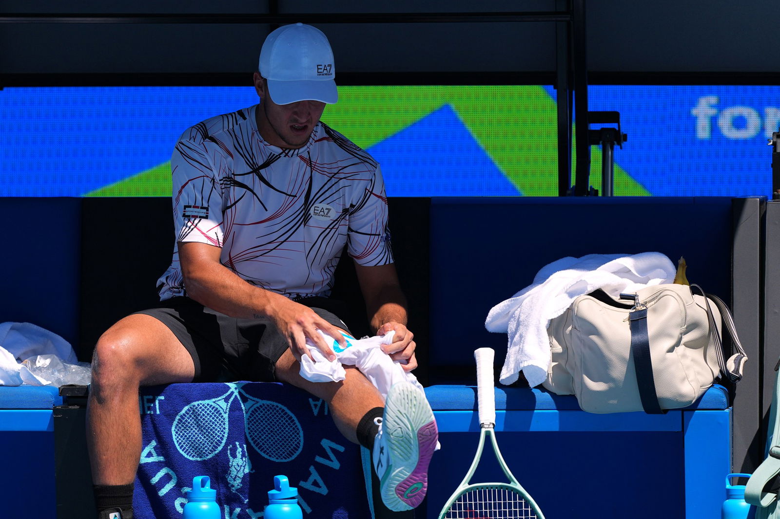 An Australian Open player applies a wet towel to his leg.
