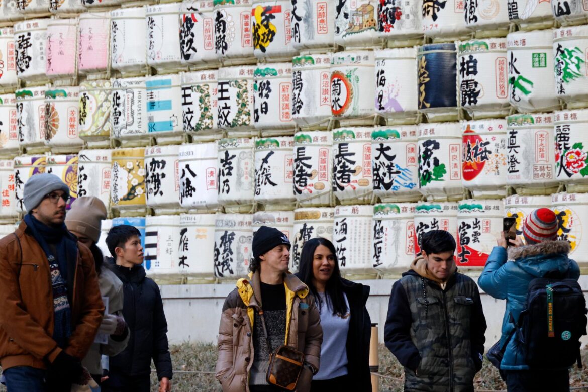 Tourists stroll past sake barrels displayed at the Meiji Jingu shrine in Tokyo, Japan,  Jan, 21. EPA-Yonhap