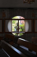 A stone lantern is seen through a circular window on one side of the sanctuary at Catholic Katsura Church in Kyoto's Nishikyo Ward, Nov. 21, 2025. (Mainichi/Takao Kitamura)