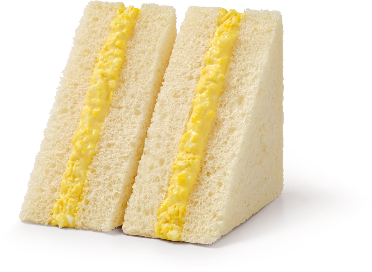 A sandwich on white bread with a fluffy yellow filling