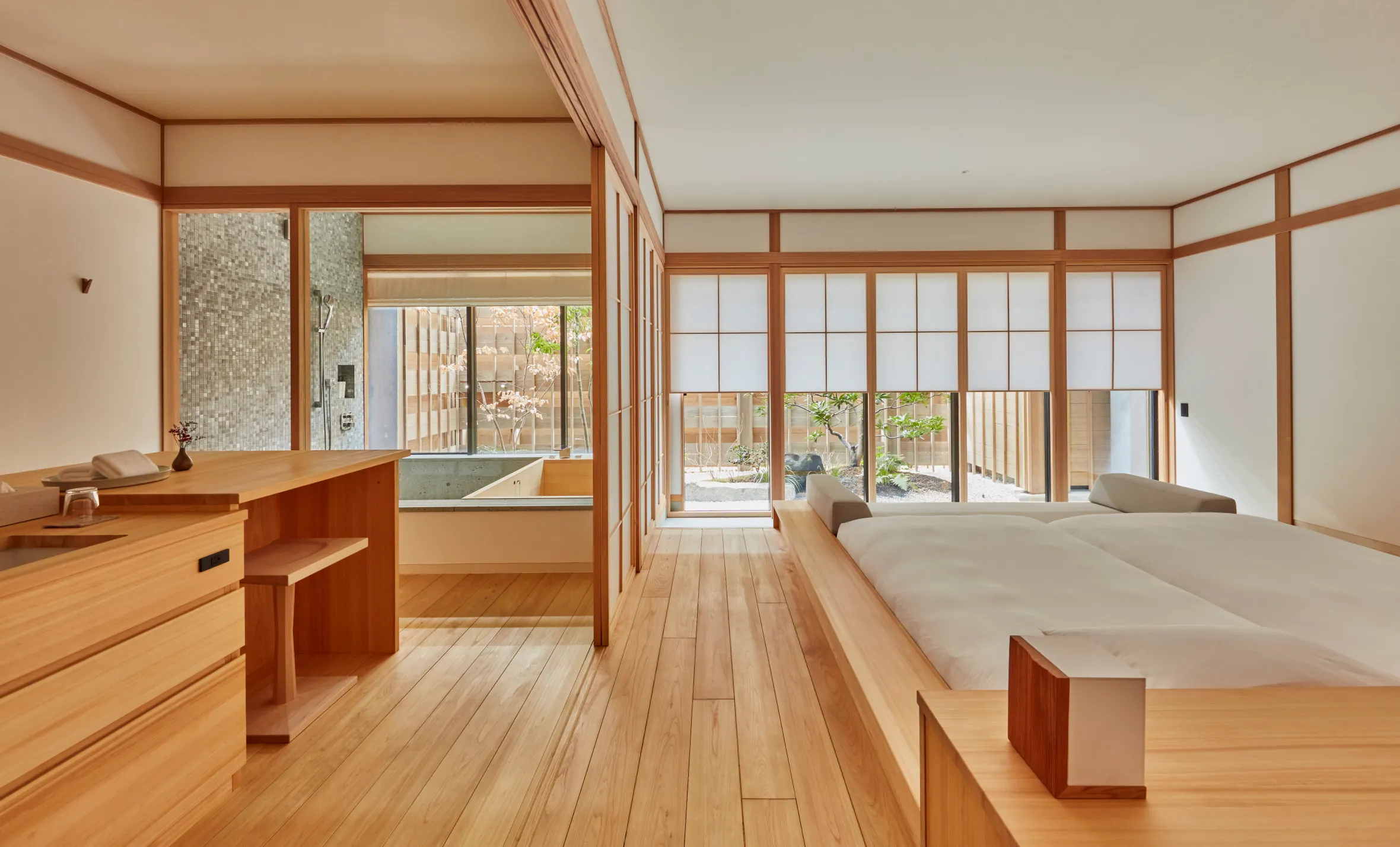 Japanese-style bedroom with wooden floors, sliding doors, and an outdoor garden view.