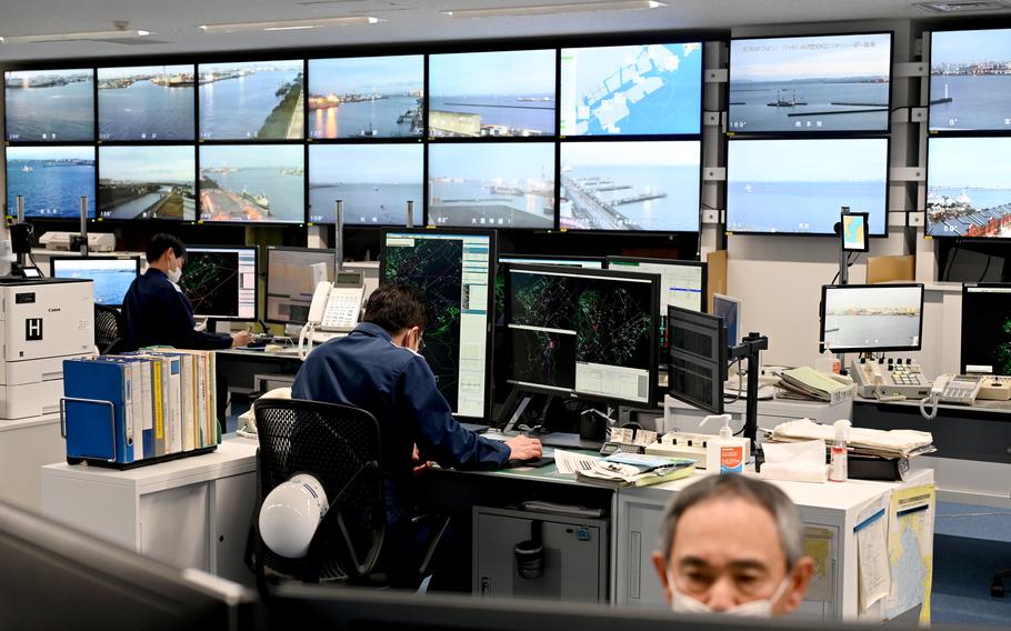 A control room with multiple large monitors displaying live waterfront and port‑area camera feeds.