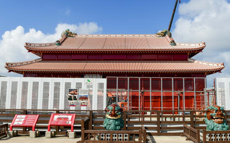 A decorative Japanese building still has construction walls and equipment around it as it undergoes renovation.