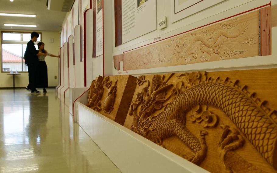 A decorative fresco runs along an interior display wall.