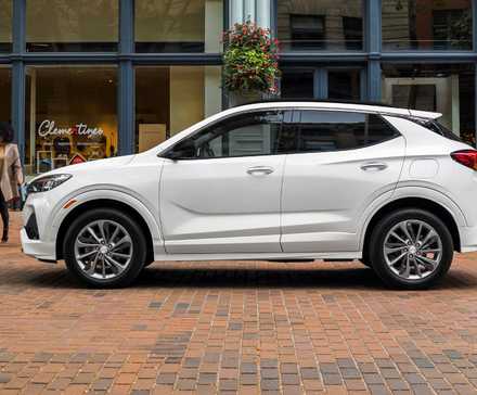 Static side profile shot of a white 2021 Buick Encore GX parked in a city.