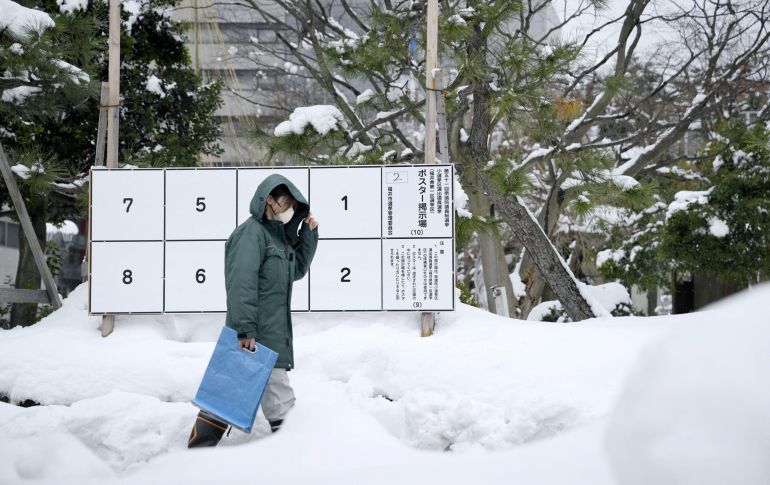 A person walks past a bulletin board for posters of candidates for the February 8 snap election, where snow has accumulated, in Fukui, Japan, January 26, 2026, in this photo taken by Kyodo. Mandatory credit Kyodo/via REUTERS ATTENTION EDITORS - THIS IMAGE WAS PROVIDED BY A THIRD PARTY. EDITORIAL USE ONLY. MANDATORY CREDIT. JAPAN OUT. NO COMMERCIAL OR EDITORIAL SALES IN JAPAN.