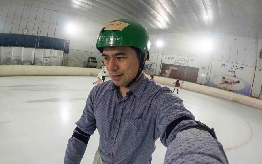 Shoji is taking a photo of himself while skating.