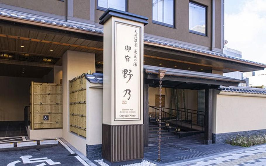 A hotel exterior is marked by a tall sign.